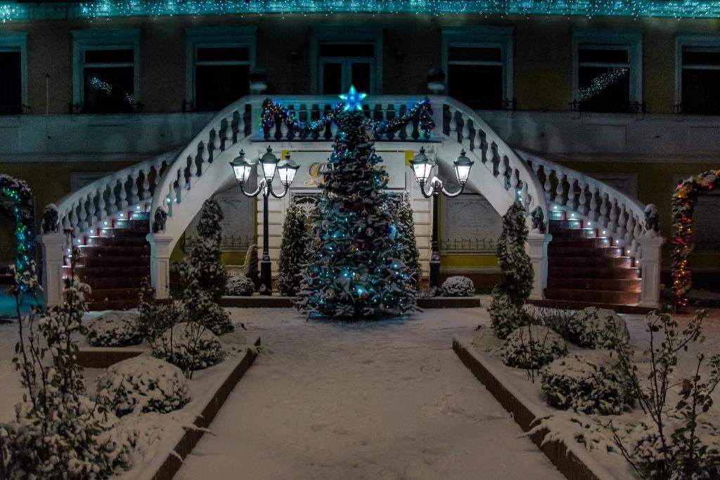 a christmas tree in the courtyard of a building at La Belle отель ресторан in Gur'yevsk