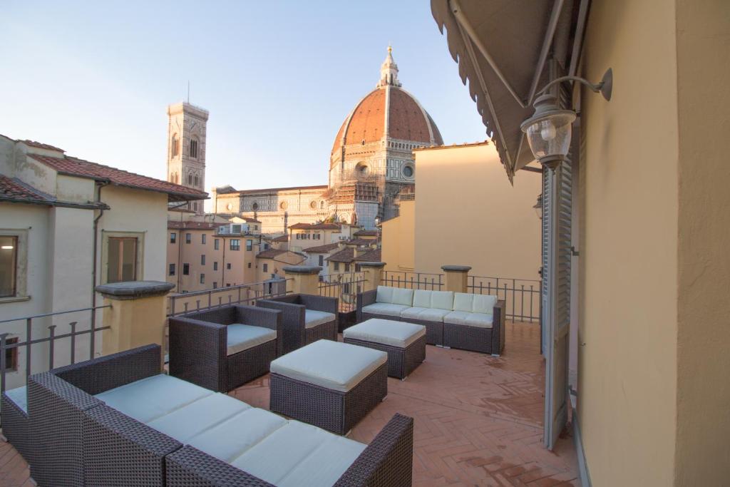 a balcony with tables and chairs on a building at Yome - Your Home in Florence in Florence