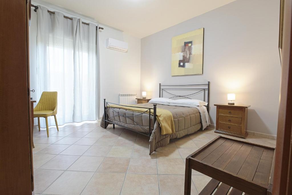 a bedroom with a bed and a table and a chair at Cannatello home - Affittacamere in Villaggio Mosè