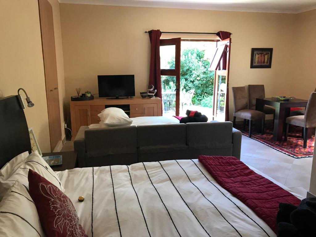 a living room with a couch and a bed at Wine Cottage by the Sea in Helderberg