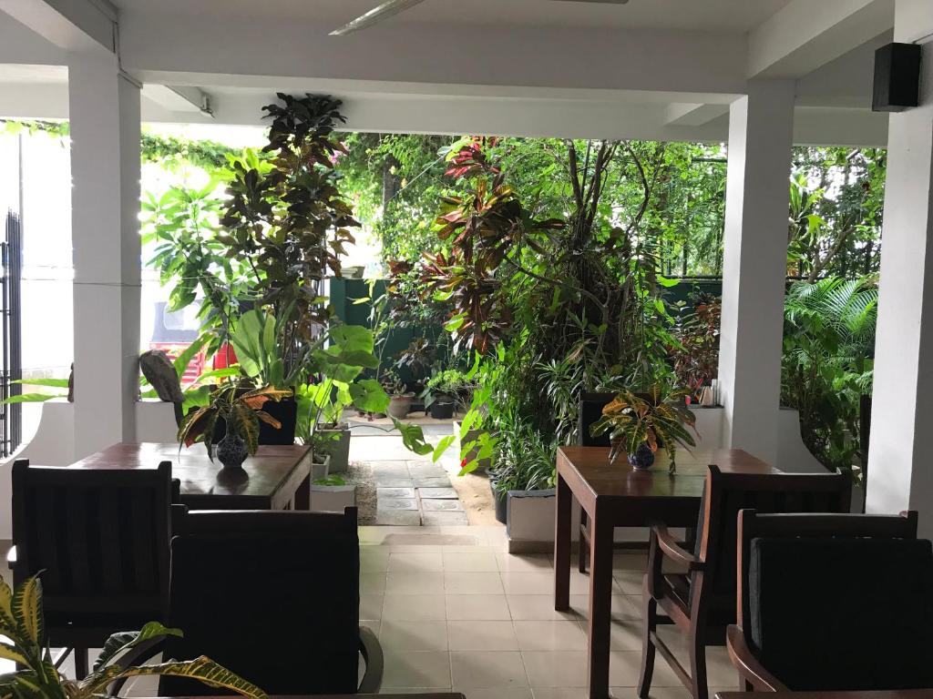 a restaurant with tables and potted plants at Unawatuna Beach Bungalow - in Unawatuna