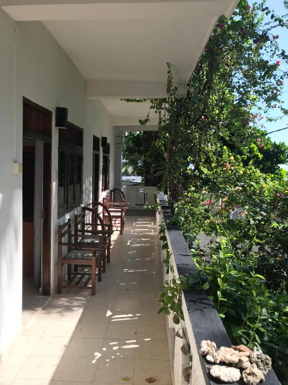 a porch of a house with benches and plants at Unawatuna Beach Bungalow - in Unawatuna