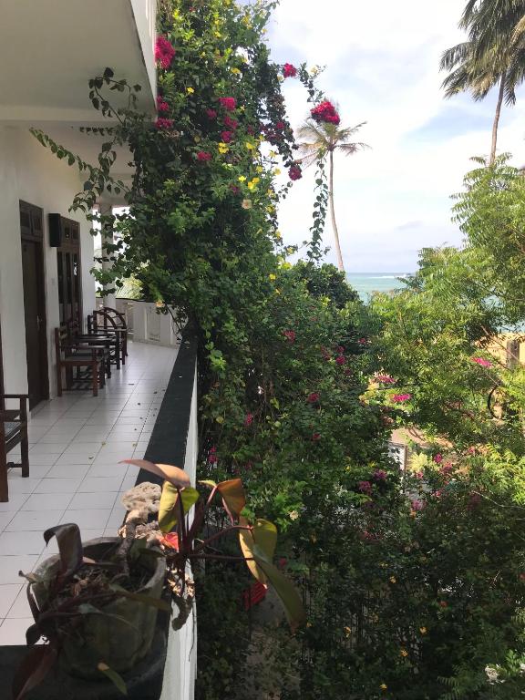 a balcony with a bunch of flowers at Unawatuna Beach Bungalow - in Unawatuna