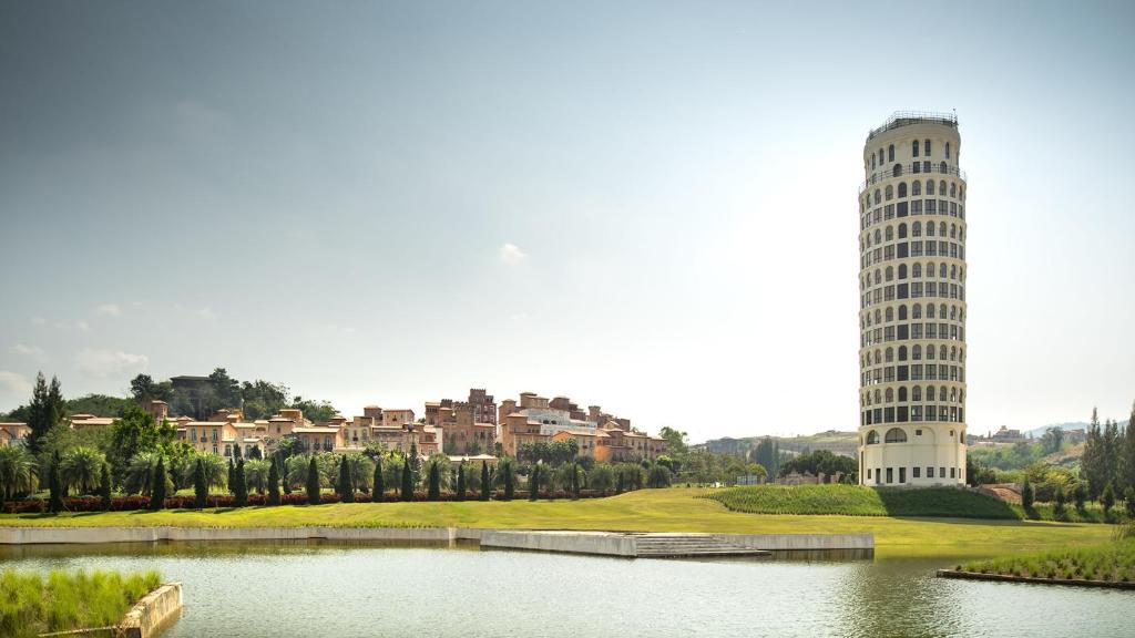 a building with a tower next to a lake at Toscana Piazza in Mu Si