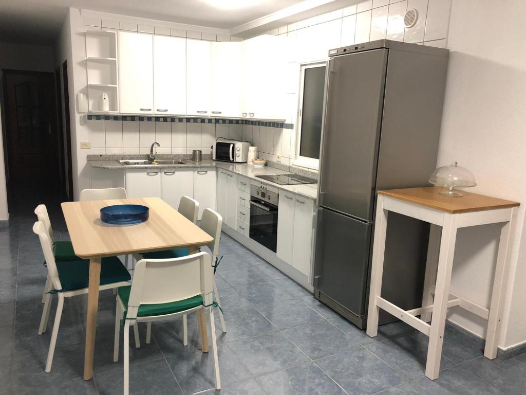 a kitchen with a table and a refrigerator at Islas Malvinas 39 Atico F in Vecindario