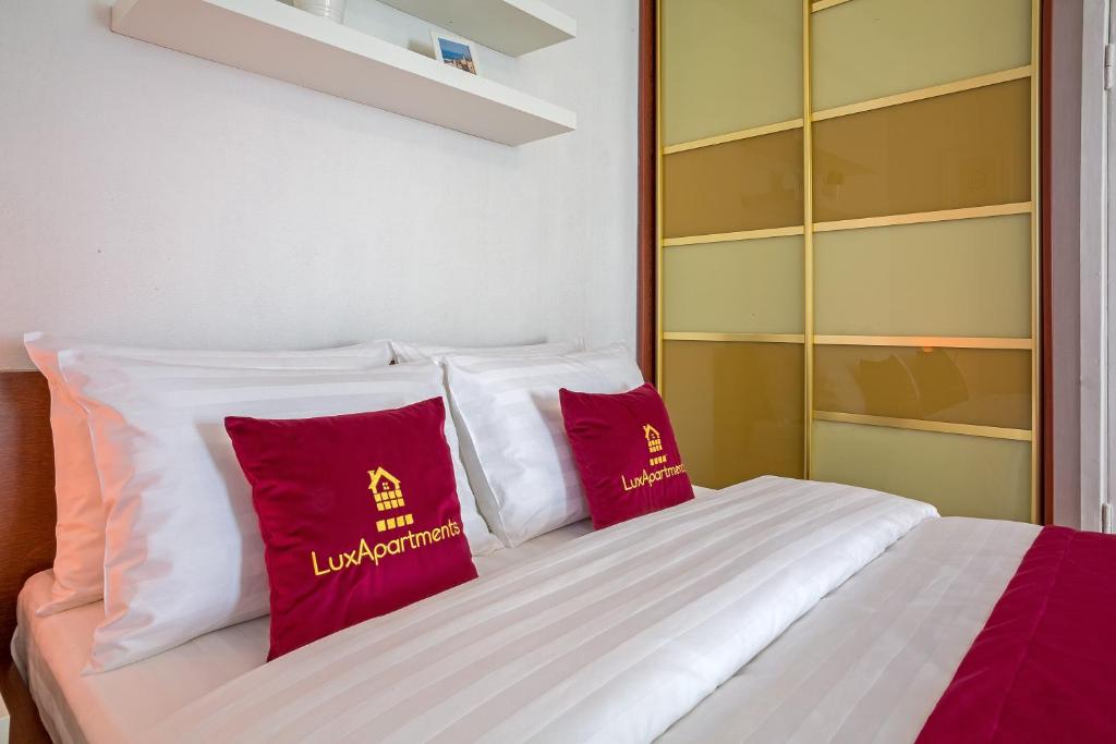 モスクワにあるLux-Apartments 3-Фрунзенская, 13のベッド1台(上に赤い枕2つ付)