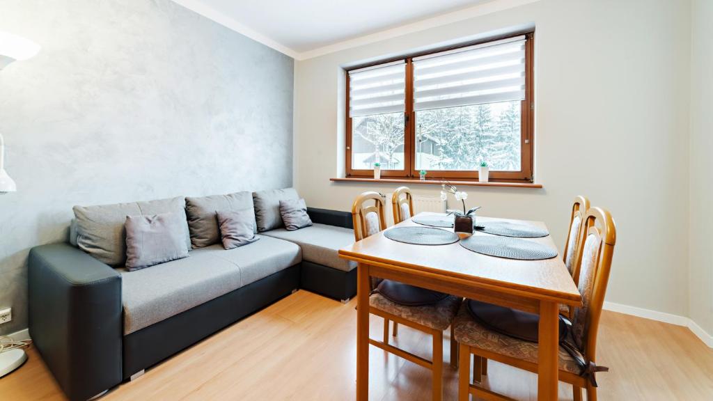 a living room with a couch and a table at Apartamenty Sun & Snow Moniuszki in Karpacz