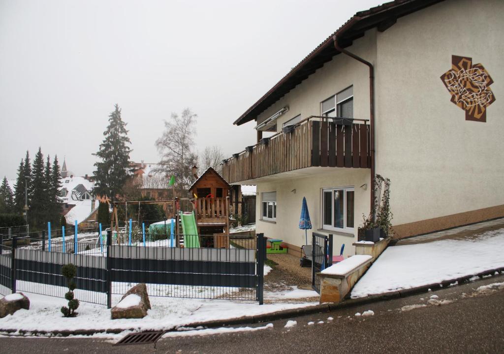 a building with a playground in the snow at Ferienwohnung Prinz-Kari in Stühlingen