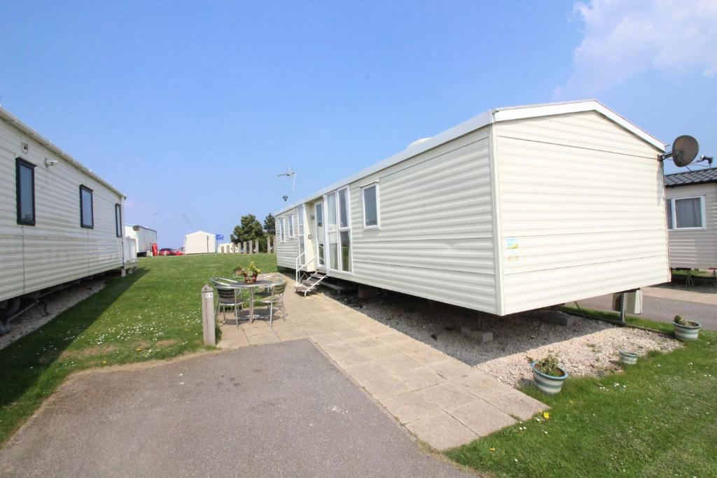 a large white trailer parked next to a building at Reighton Sands 1 in Filey