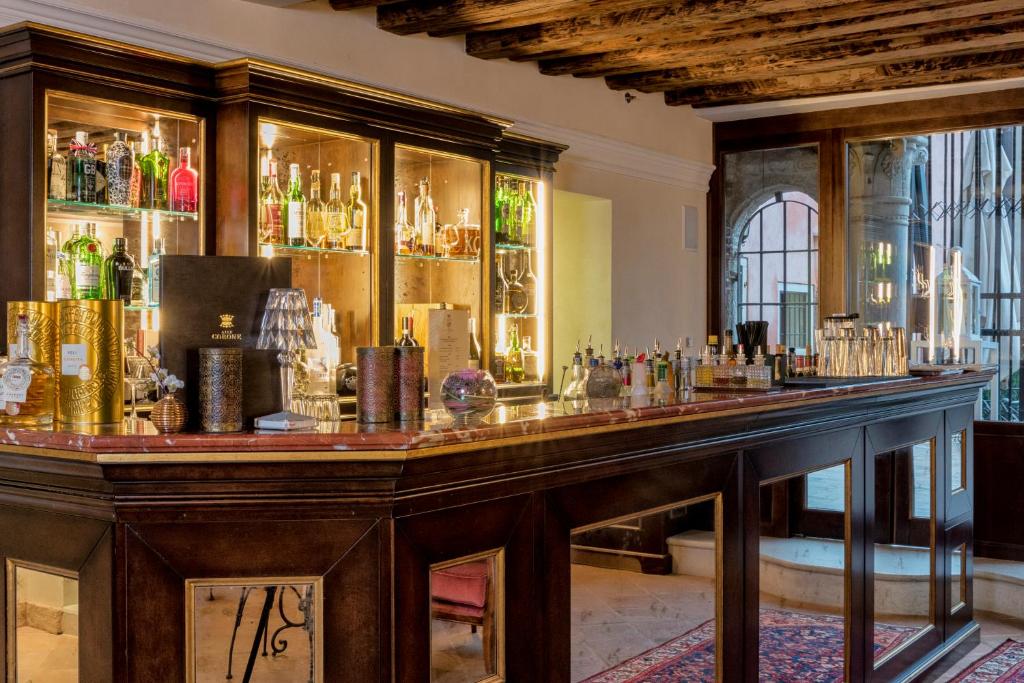 a bar with a lot of liquor bottles at Hotel Nani Mocenigo Palace in Venice