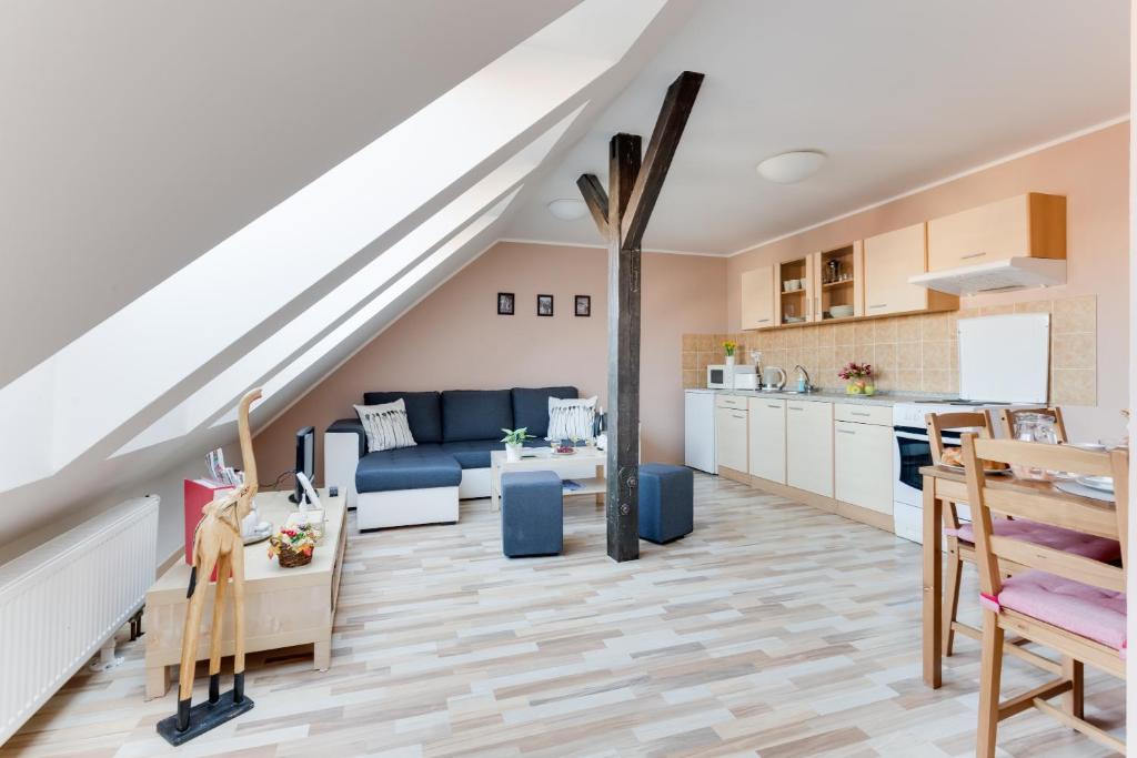 a kitchen and a living room with a staircase at Jane's Attic Apartment in Prague