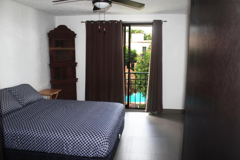 a bedroom with a bed and a door to a balcony at Casa Wilo in Cancún