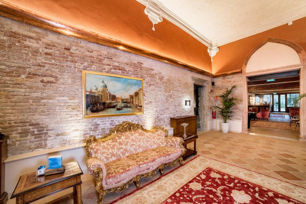 a living room with a couch and a brick wall at Hotel Nani Mocenigo Palace in Venice