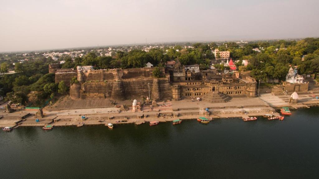 Ahilya Fort في Maheshwar: اطلالة جوية على قلعة بجانب الماء