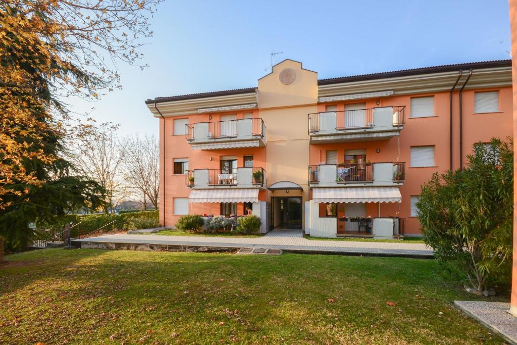 een appartementencomplex met een gazon ervoor bij Casa vacanze con ampia piscina"Lago e Terme" in Sirmione