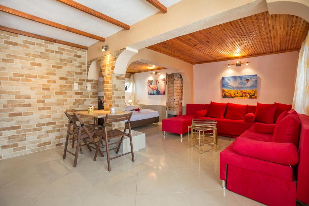 a living room with a red couch and a table at Villa Elpis 2 in Limenaria