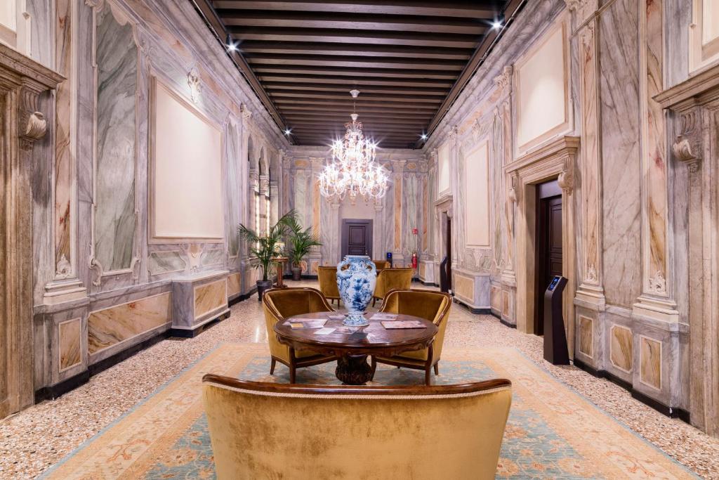 a room with a table and chairs and a chandelier at Hotel Nani Mocenigo Palace in Venice