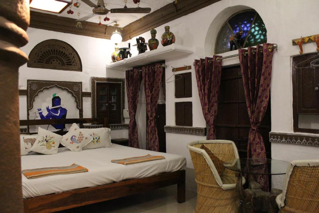 1 dormitorio con 1 cama con mesa y sillas en Castle View Heritage Haveli, en Jodhpur