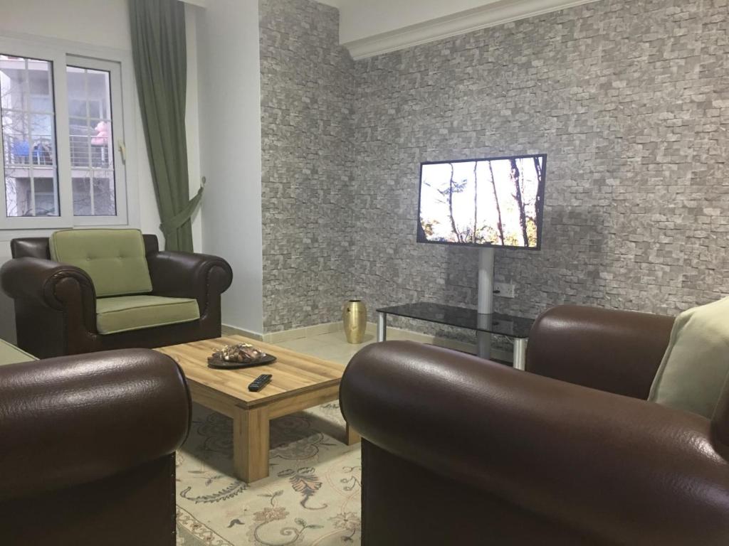a living room with leather chairs and a tv at Royal Residence Kyrenia in Kyrenia