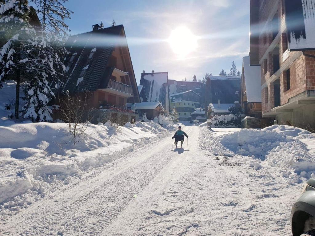 a person is skiing down a snow covered street at Apartments A Vlasic in Vlasic