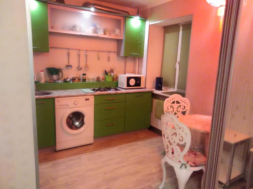 ドニプロにあるАпартаменты Летоのキッチン(緑のキャビネット、洗濯機付)