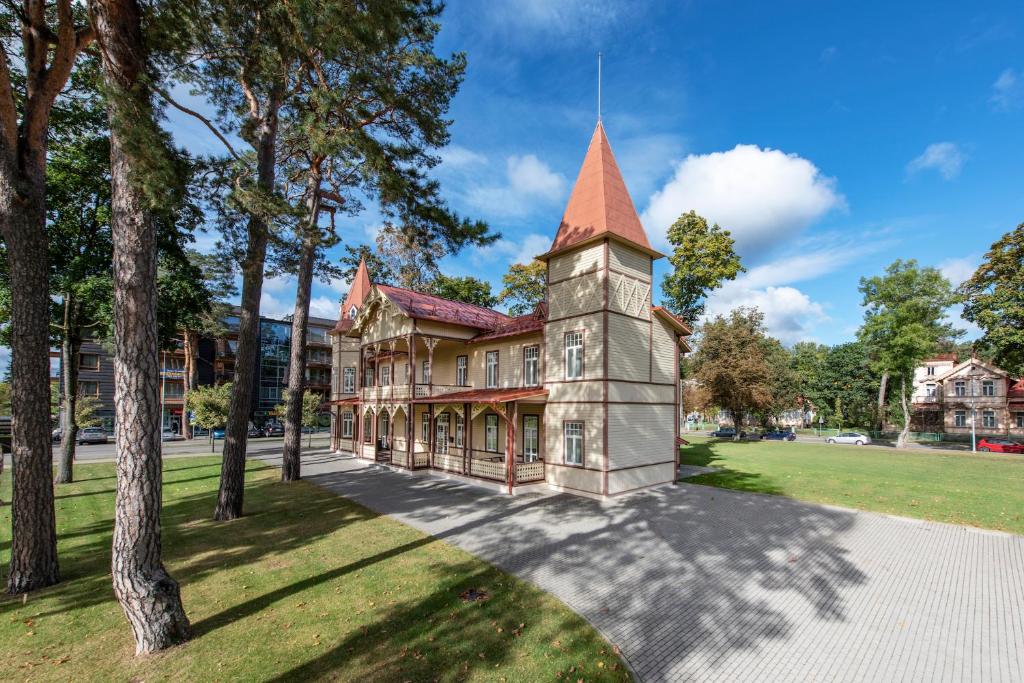 uma casa velha com uma torre num parque em Vila''RADIUM'' em Druskininkai