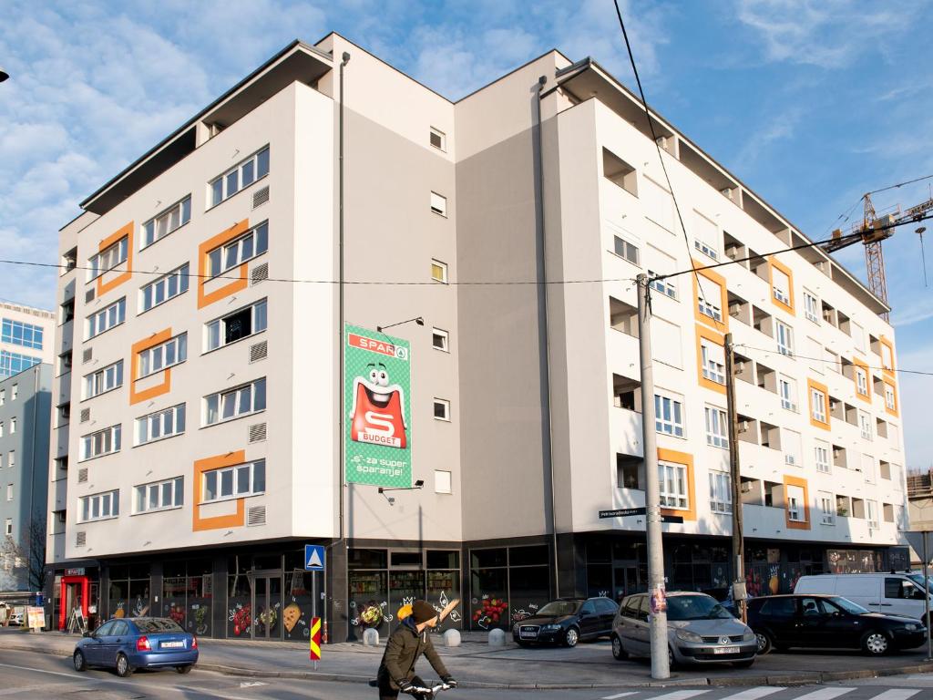 a white building on a city street with cars at Flexible SelfCheckIns 7 - Zagreb - Garage - Electric vehicle ccharger - Loggia - New - Luxury - Apartments Repinc 7 in Zagreb