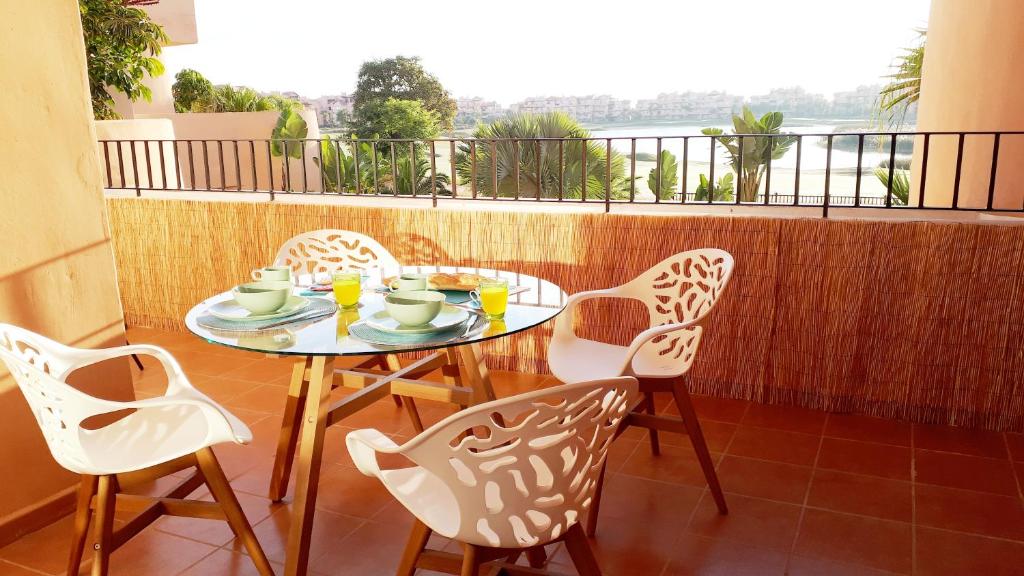 トレ・パチェコにあるLuxe appartement on Mar Menor Golf Resort with Padel, Fitness, Wellness facilitiesの景色を望むバルコニー(テーブル、椅子付)