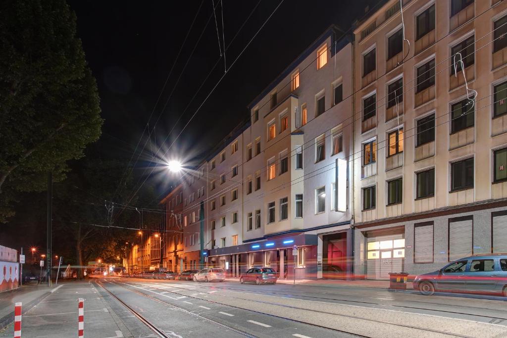 una calle de la ciudad por la noche con un edificio en Sure Hotel by Best Western Ambassador Duesseldorf, en Düsseldorf