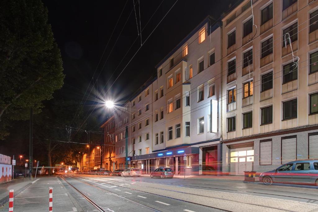 eine Stadtstraße bei Nacht mit einem Gebäude in der Unterkunft Hotel Ambassador Duesseldorf in Düsseldorf
