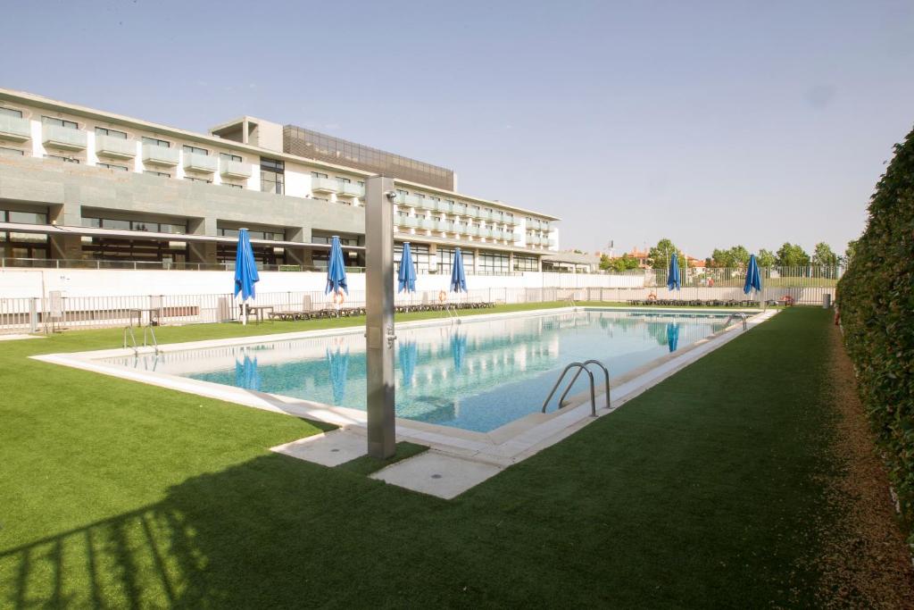 a large swimming pool in front of a building at Occidental Aranjuez in Aranjuez