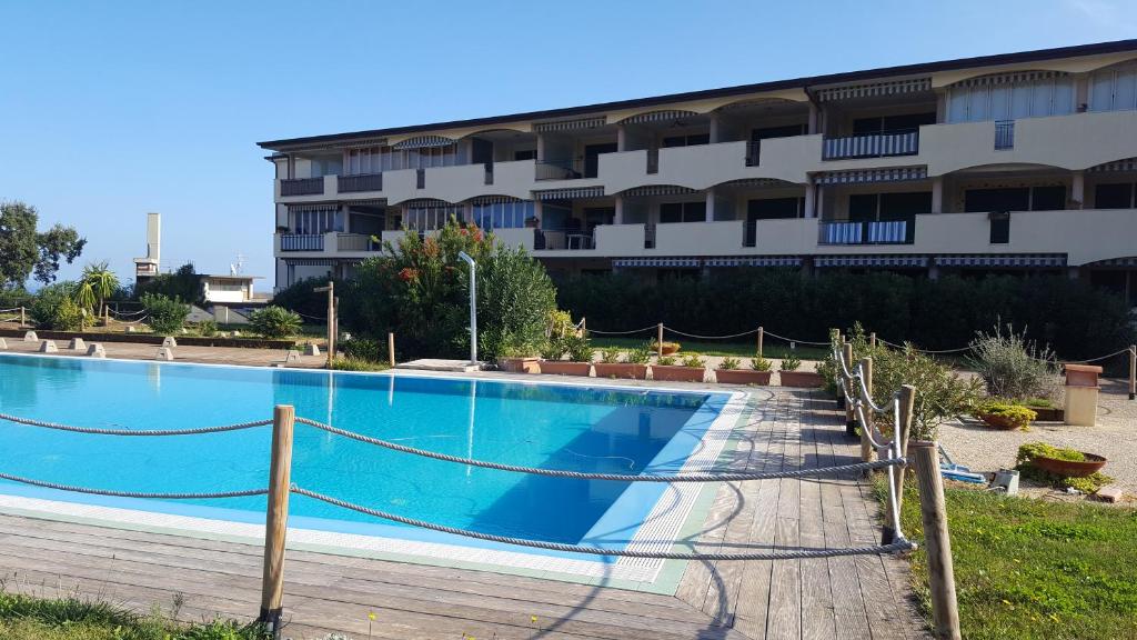 a large swimming pool in front of a building at residenza " Verde Blu " in Capoliveri