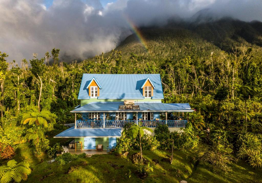 a house in the mountains with a rainbow in the background at Harmony Villa in Pont Cassé