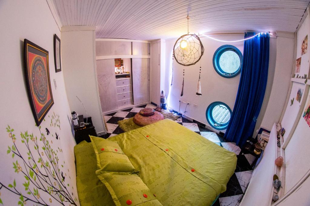 a small room with a green bed in a room at Mandala Yoga Hostel in Bogotá