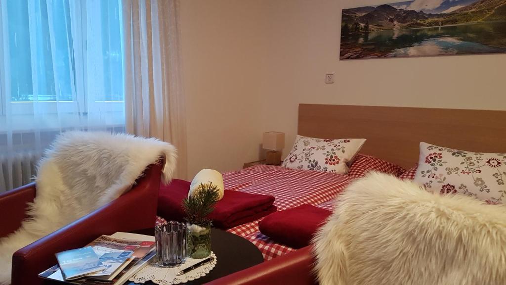 a living room with a red couch and a bed at Haus Sabine in Schruns