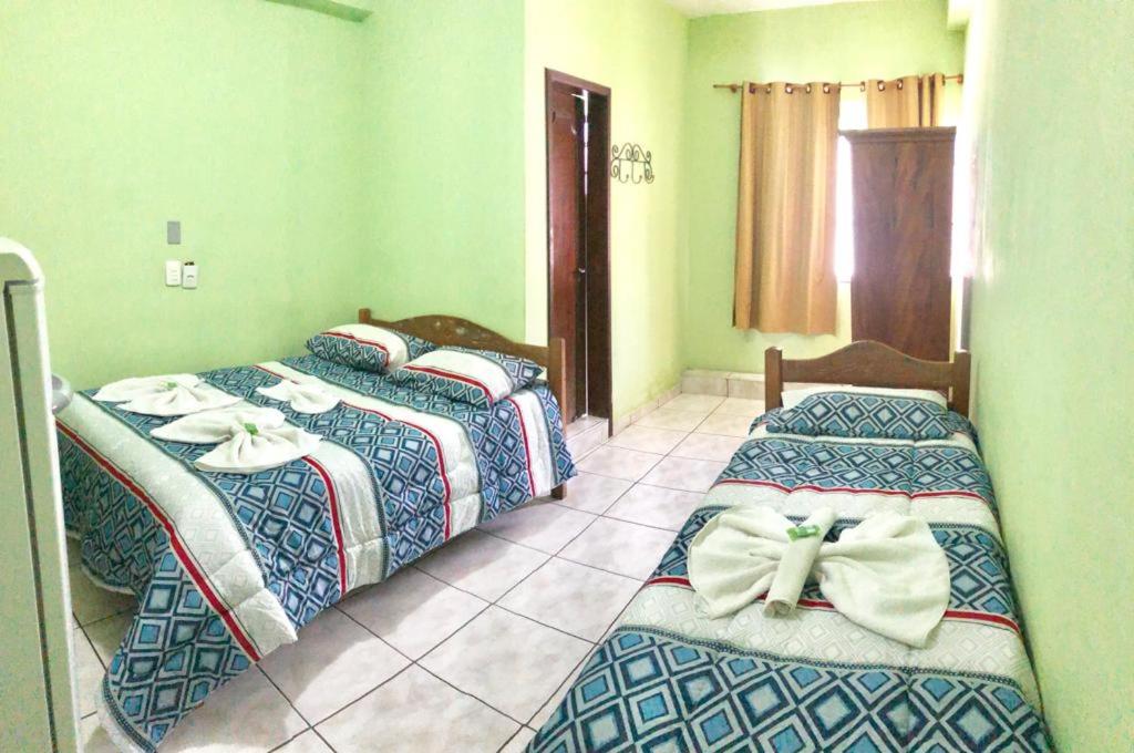 a bedroom with two beds with bows on them at Hotel Cristo Rei 611 in São João del Rei