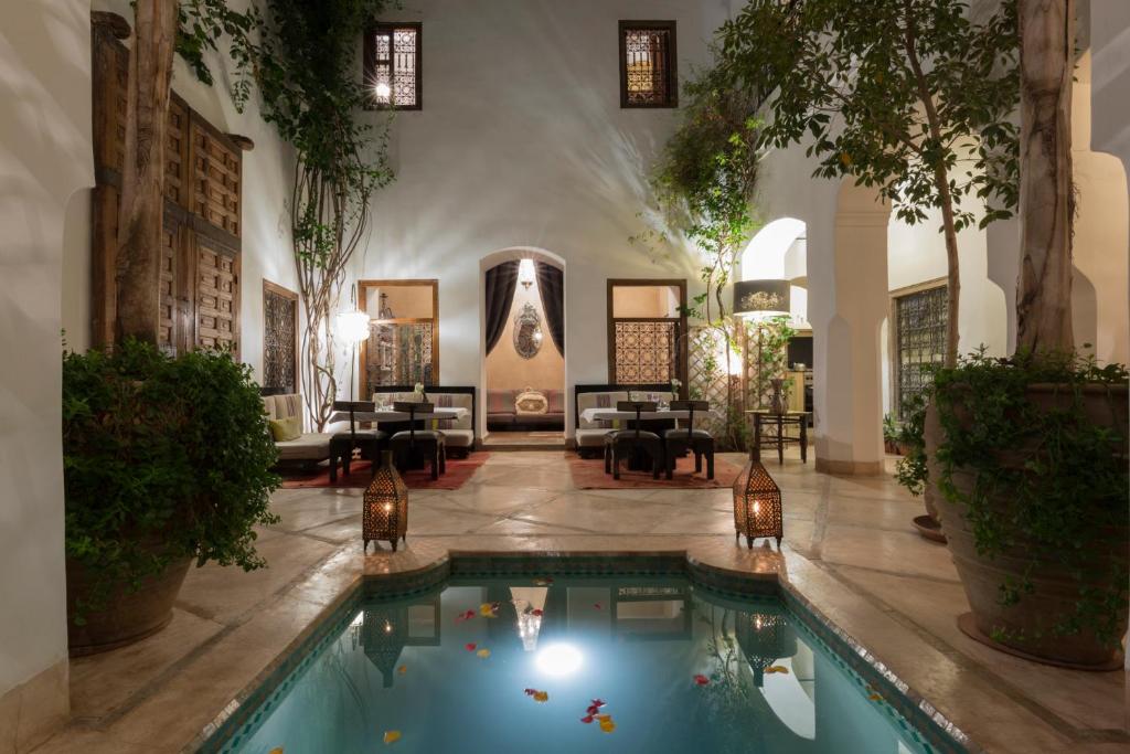 een lobby met een zwembad in het midden van een gebouw bij Riad El Maktoub in Marrakesh