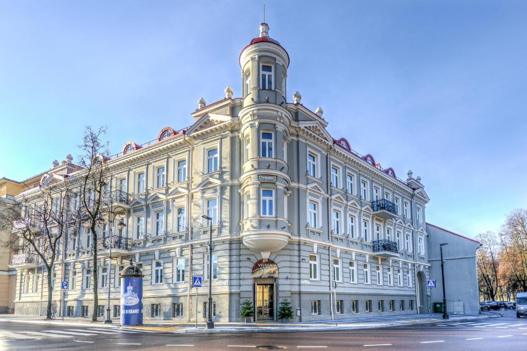 a large white building with a tower at Hotel Vilnia in Vilnius