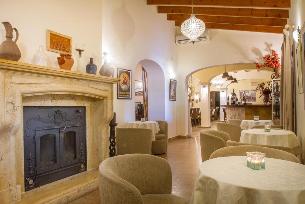a restaurant with tables and chairs and a fireplace at Hotel Tossal d'Altea in Altea
