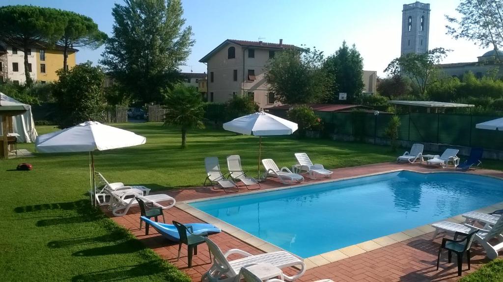 a swimming pool with chairs and umbrellas at B&B Il Casale di Nanni in Lucca