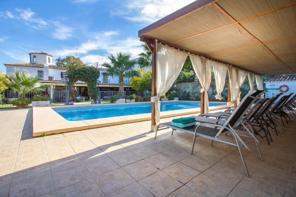 a patio with chairs and a swimming pool at Hotel Tossal d'Altea in Altea