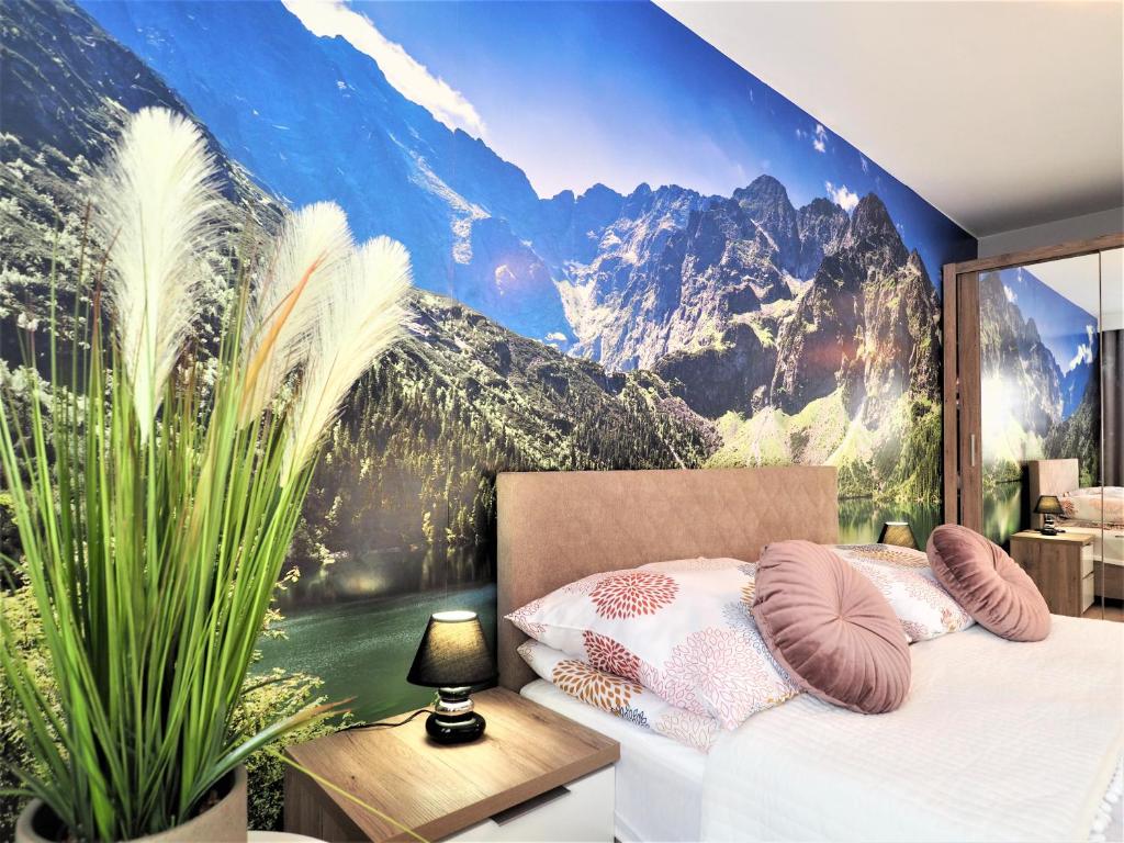 a bedroom with a mountain mural on the wall at VIP Apartamenty Kasprusiowy Zakatek in Zakopane