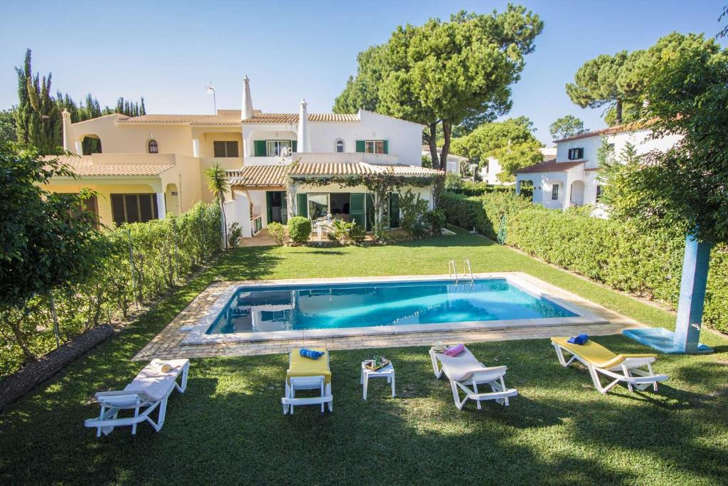 an external view of a house with a swimming pool at Casa Clara in Vilamoura