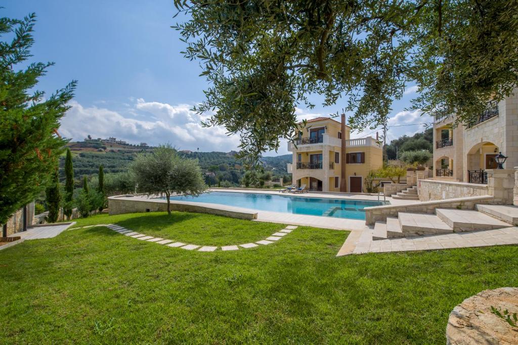 a house with a swimming pool in a yard at Casa Leone Suites in Stalos