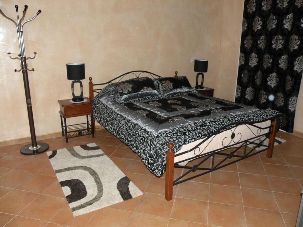 uma cama num quarto com dois candeeiros e um tapete em Villa El Andalousse em Larache