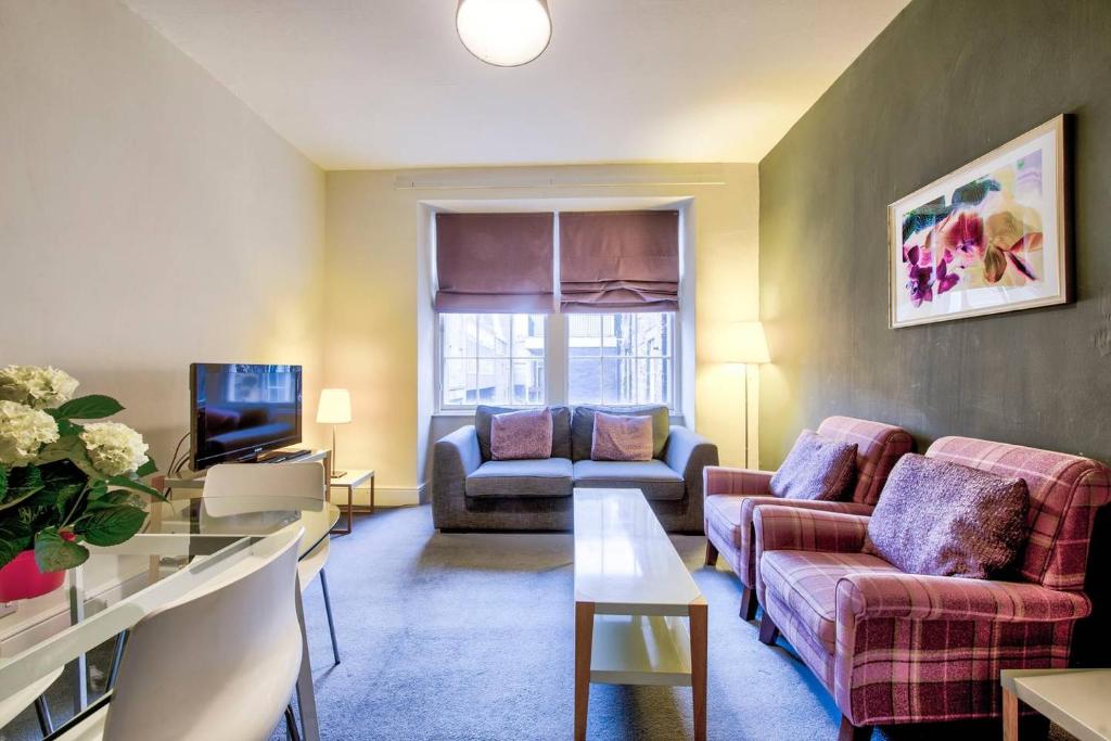 a living room with two couches and a tv at ALTIDO Perfect Location! - Stylish & Cosy Rose St Apt in Edinburgh