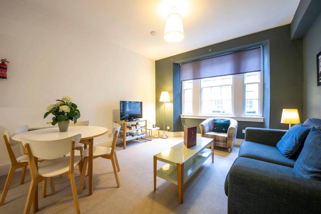 uma sala de estar com um sofá e uma mesa em ALTIDO Perfect Location! Charming Rose St Apt for Couples em Edimburgo