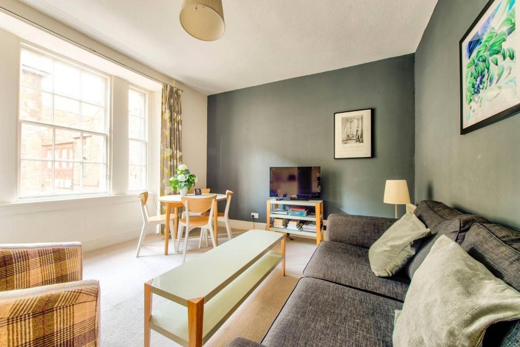 uma sala de estar com um sofá e uma mesa em JOIVY Amazing Location! - Lovely Rose St Apt in New Town em Edinburgo