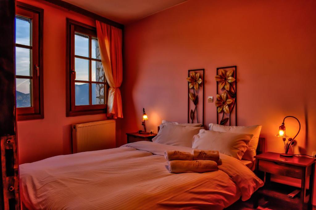 a bedroom with a bed with orange walls and windows at Dio Studios in Arachova