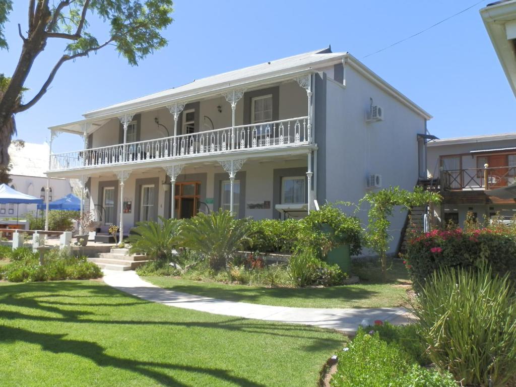 a large white house with a balcony at Towerzicht Guest House in Ladismith